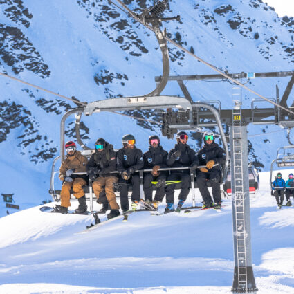 European Snowsport Ski Instructors on a chairlift smiling